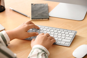 Female programmer typing on computer keyboard in office, closeup