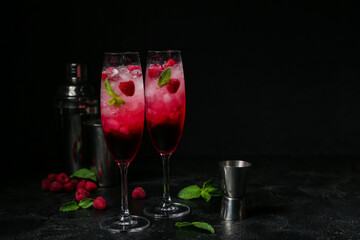 Glasses of fresh raspberry mojito on black background