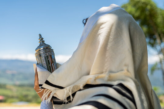 Jewish Man Covered with a Tallit Holding a Sefer Torah Outdoors