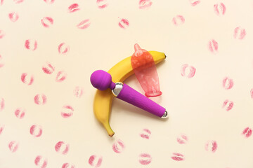 Vibrator, condom, banana and lipstick kiss marks on color background