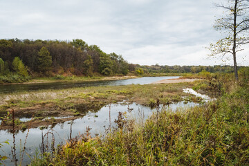 A Beautiful Tranquil River Landscape Featuring Lush Vegetation and a Dramatic Overcast Sky that Invites Exploration and Adventure