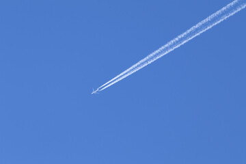 Telephoto close-up of jet plane aircraft with contrails cruising on the scottish sky