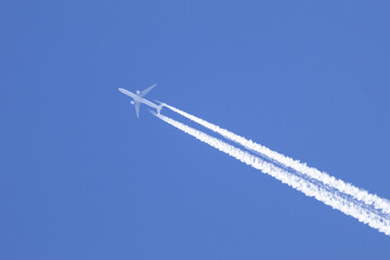 Telephoto close-up of jet plane aircraft with contrails cruising on the scottish sky