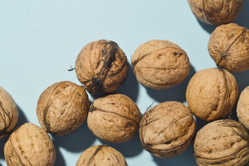 minimal close up whole walnuts on blue background, copy space, frame, top down view