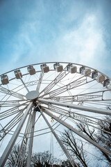 Obraz premium Ferris Wheel on bright blue skies, trees in the background