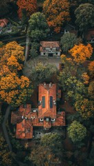 Naklejka premium An aerial view of a house with a red tile roof surrounded by lush autumn foliage.