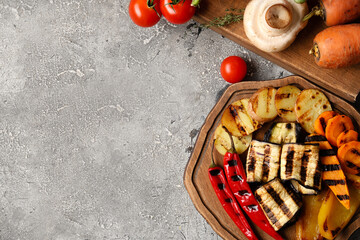 Wooden tray with grilled vegetables on grunge background