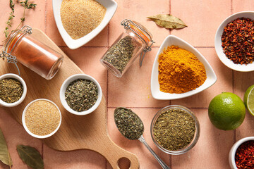 Composition with different aromatic spices and lime on color tile table