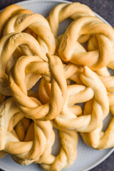 Ciambelle di pane. Crispy italian salted donuts on plate on black table. Top view.