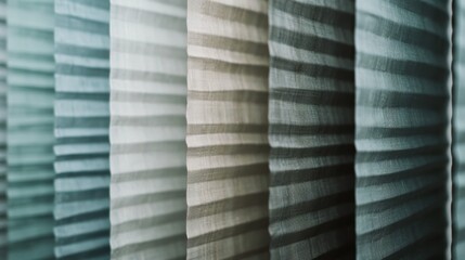Obraz premium Light filters through layered, semi-transparent pleated fabric, creating a gradient effect with varying shades of soft blues and grays.