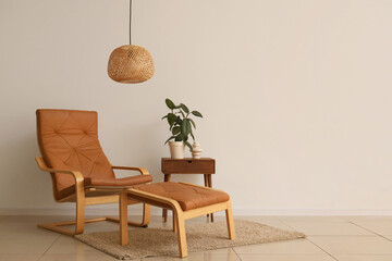 Interior of living room with wicker lamp, armchair and ottoman