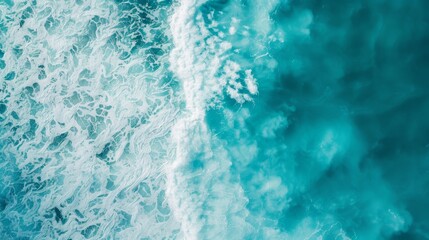 Fototapeta premium Aerial view of pristine, turquoise waves crashing on the beach, showcasing the natural beauty and serene atmosphere of the coastline.
