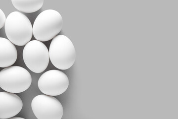 Raw chicken eggs on grey background