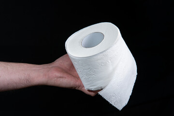 Close-up of a man's hand holding a roll of white toilet paper