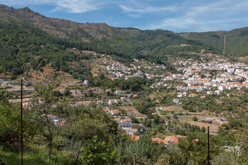 Fototapeta premium Vista panorâmica da Serra da Estrela, com seus imponentes picos rochosos, vastos campos verdes e céu claro, oferecendo uma paisagem tranquila e natural da maior montanha de Portugal.