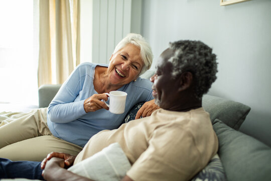 Diverse senior couple relaxing together on the couch at home