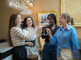 Portrait girl friendship group woman african and caucasian  celebrating smile happy enjoying people bar hand holding drink glass wine and red wine bottle on dinner at party in pub and restaurant