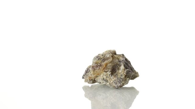 Cordierite mineral stone spinning in a circle on a white background