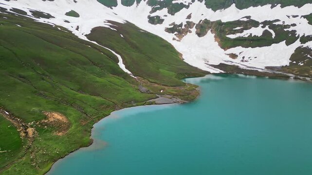 Dudipatsar Lake, a pristine blue alpine lake nestled among the snow-capped mountains of Pakistan's Kaghan Valley.