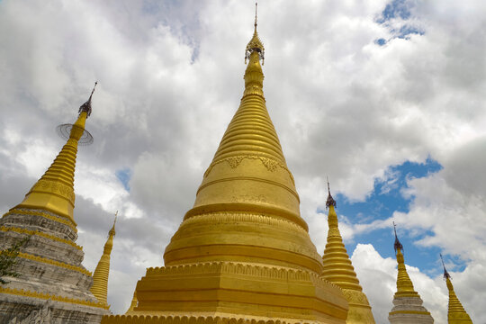 Golden pagodas under a dramatic sky in Pindaya, Myanmar