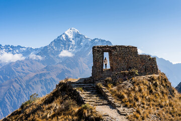 young woman looking at the imposing intipunku 