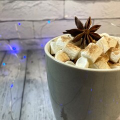 Cozy winter photo with coffee and marshmallow and garland christmas new year holiday home 