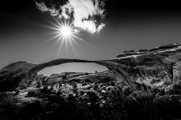 Landscape Arch in BW In the quiet expanse of Arches National Park I set out to capture the renowned Landscape Arch. As the sun began its slow descent, I found the perfect spot directly in line with it