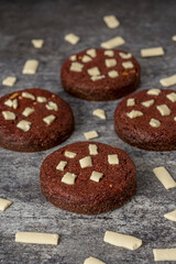 Homemade red cookie with white chocolate on a grey background