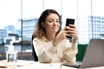 Female CEO discussing business ideas with her team on social media, receiving project updates form employees via text messages. Successful goal oriented entrepreneur with determination.