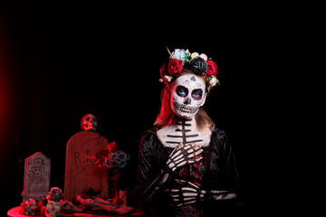 Portrait of mysterious witch at religious processions during Dia de los Muertos november holiday. Woman dressed as La Catrina wearing skeleton makeup symbolizing reverence for deceased