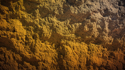 Warm-toned stone texture with shades of yellow, brown, and orange, offering rugged details perfect for natural backgrounds, wallpapers, and design projects