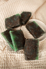 Handmade Green and Brown Soap Bars Resting on a Soft Towel
