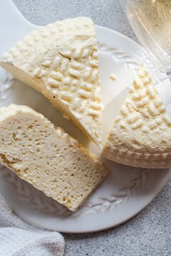 Sulguni cheese and amber wine on white ceramic plate