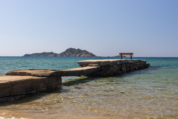 Naklejka premium Bench on pier overlooking the sea