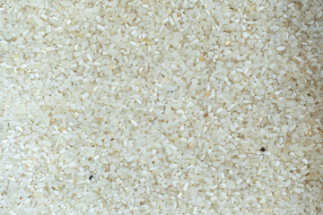 Above view of broken white rice grains. for backgorund and textured.