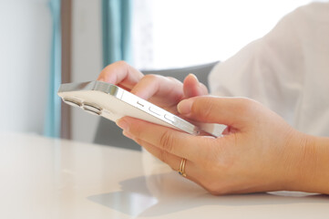スマホを操作する女性（顔なし）