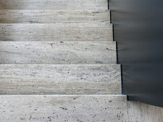 Top view of stone stairs with black railing