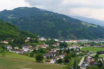 Picturesque landscape of a charming village surrounded by lush hills in Austria on a tranquil cloudy afternoon