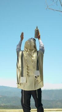 Jewish Man Kissing and Lifting a Torah Scroll to the Sky, Dancing Joyfully in Celebration of Simchat Torah