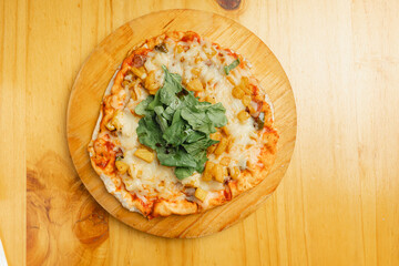 A delicious pizza is resting on a wooden cutting board on a sturdy wooden table