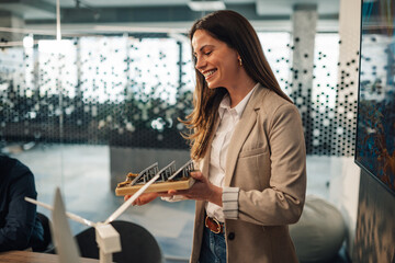 Smiling businesswoman with solar panel representing sustainable ideas.