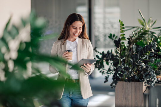 Happy smart causal businessman with tablet at office drinking coffee. - Powered by Adobe