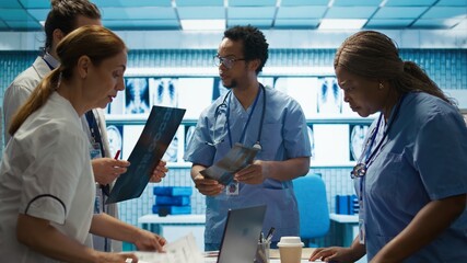Physicians and radiologists analyzing x ray scans to create an effective treatment plan. Medics doing teamwork at a private clinic to ensure radiography based diagnostics for healthcare. Camera B.