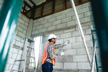 An engineer inspects construction operations and assesses the structural integrity of a house. This process ensures safety and adherence to building standards.