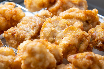 揚げバットに上げられた、揚げたての鶏もも肉の唐揚げ。
