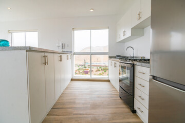 cocina de departamento con estufa muebles altos y bajos