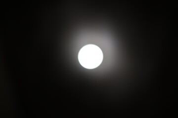 The bright light of a lightbulb is captured on the ceiling, its glow illuminating the darkness.