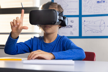Using VR headset, boy in school exploring virtual reality in classroom