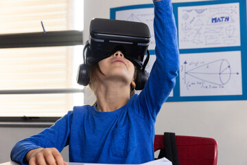 In school, boy using VR headset for interactive learning in classroom