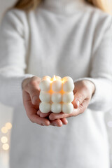 Woman holding burning candle with wooden wick, closeup